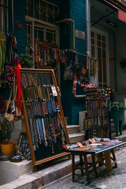 Free Colorful handmade necklaces and bracelets showcased in a bustling street market. Stock Photo