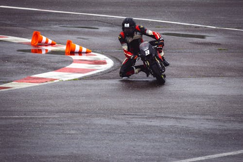 A person riding a motorcycle on a wet track