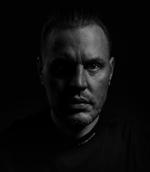 A man in black and white with a dark background