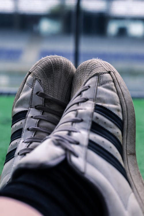 A person's feet in sneakers on a soccer field