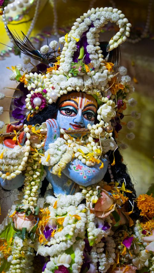 Free Colorful and ornate Hindu deity sculpture adorned with vibrant flowers and beads, symbolizing spirituality. Stock Photo