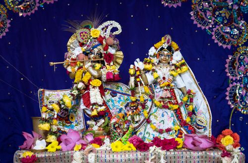 Free Vibrant sculptures of Indian deities adorned with flowers on a blue background. Stock Photo