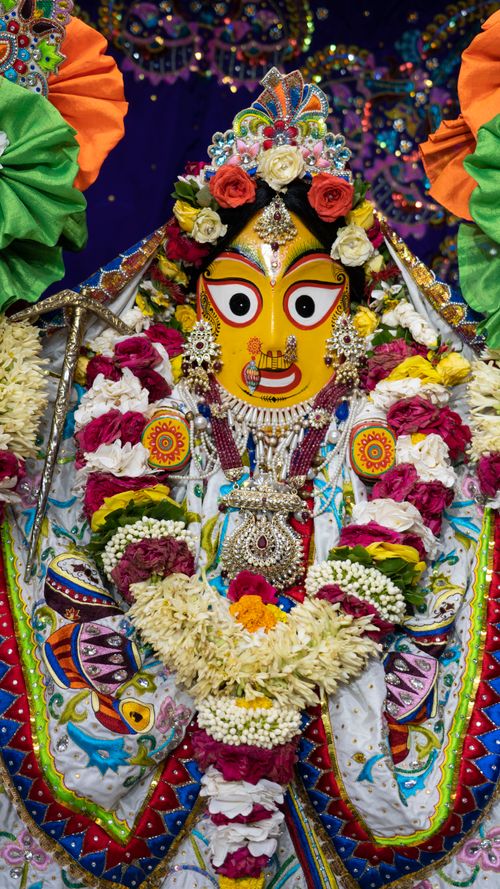 Free Colorful Krishna sculpture decorated with flowers and intricate designs, embodying spiritual festivity. Stock Photo