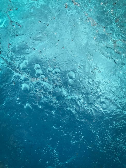 Detailed shot of bubbles in blue water creating a textured background.