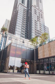 城市景观中展示着现代摩天大楼，一位穿着随意的女人在户外