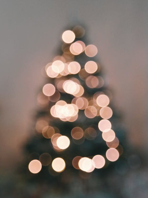 Defocused Image of Illuminated Christmas Tree Against Sky