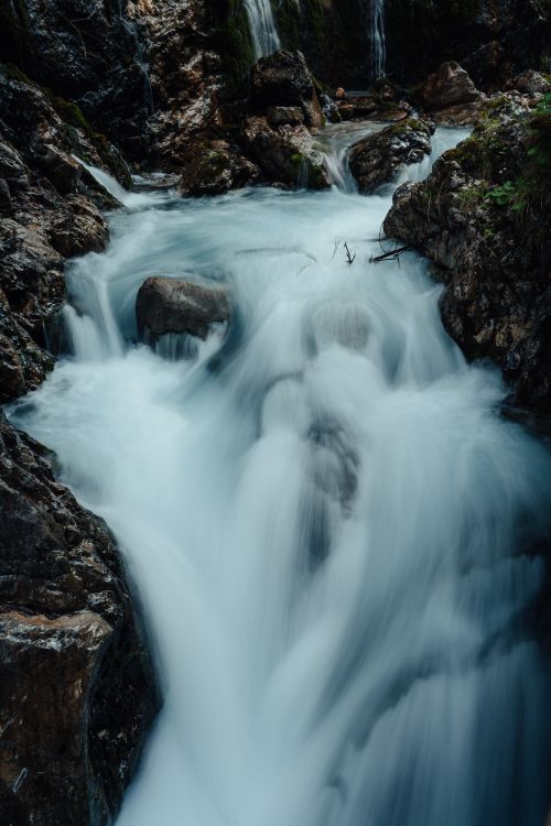 Free A mesmerizing waterfall cascading through rocks in a forested area, showcasing the purity of nature. Stock Photo