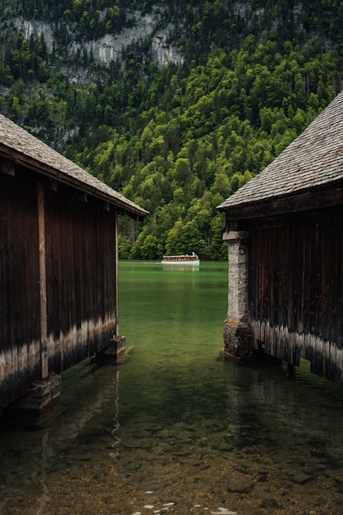 Two wooden buildings sit on the shore of a lake
