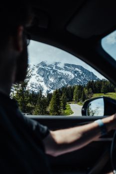 View from inside a car of a scenic mountain road covered with snow, highlighting the beauty of winter travel.