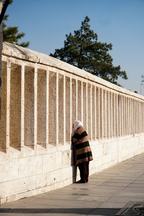 A woman is standing in front of a wall