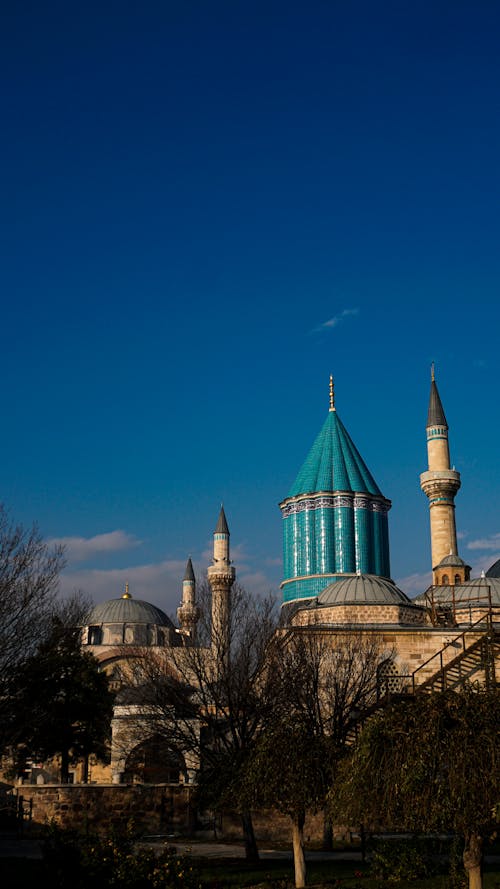 A blue mosque with a green dome and blue minarets