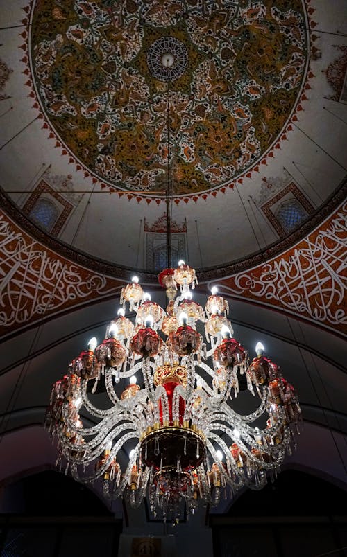 A chandelier hanging from the ceiling of a mosque