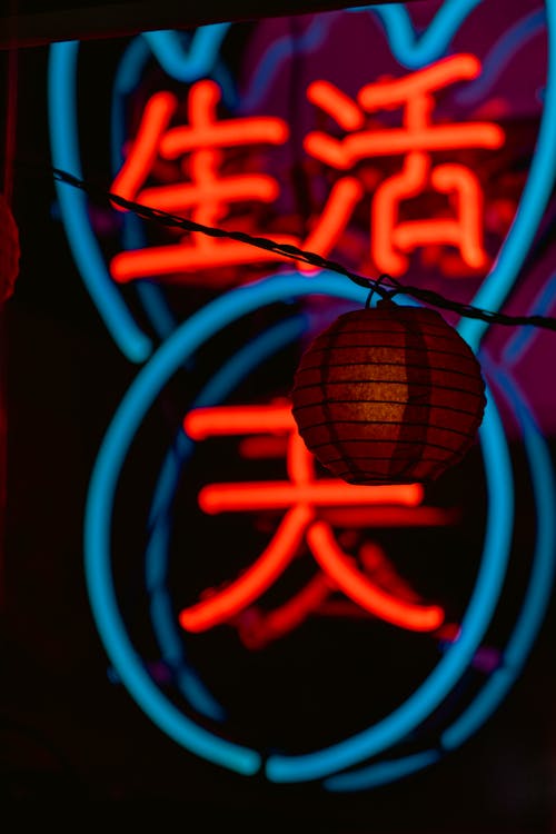 A neon sign with chinese characters and a lantern