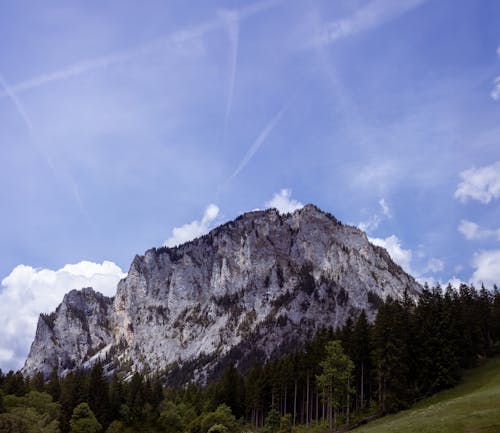 A mountain with a blue sky and clouds