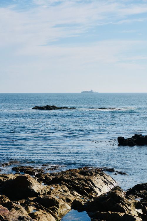 Free Peaceful ocean scene from Matosinhos, Portugal, featuring rocky shoreline and distant ship. Stock Photo