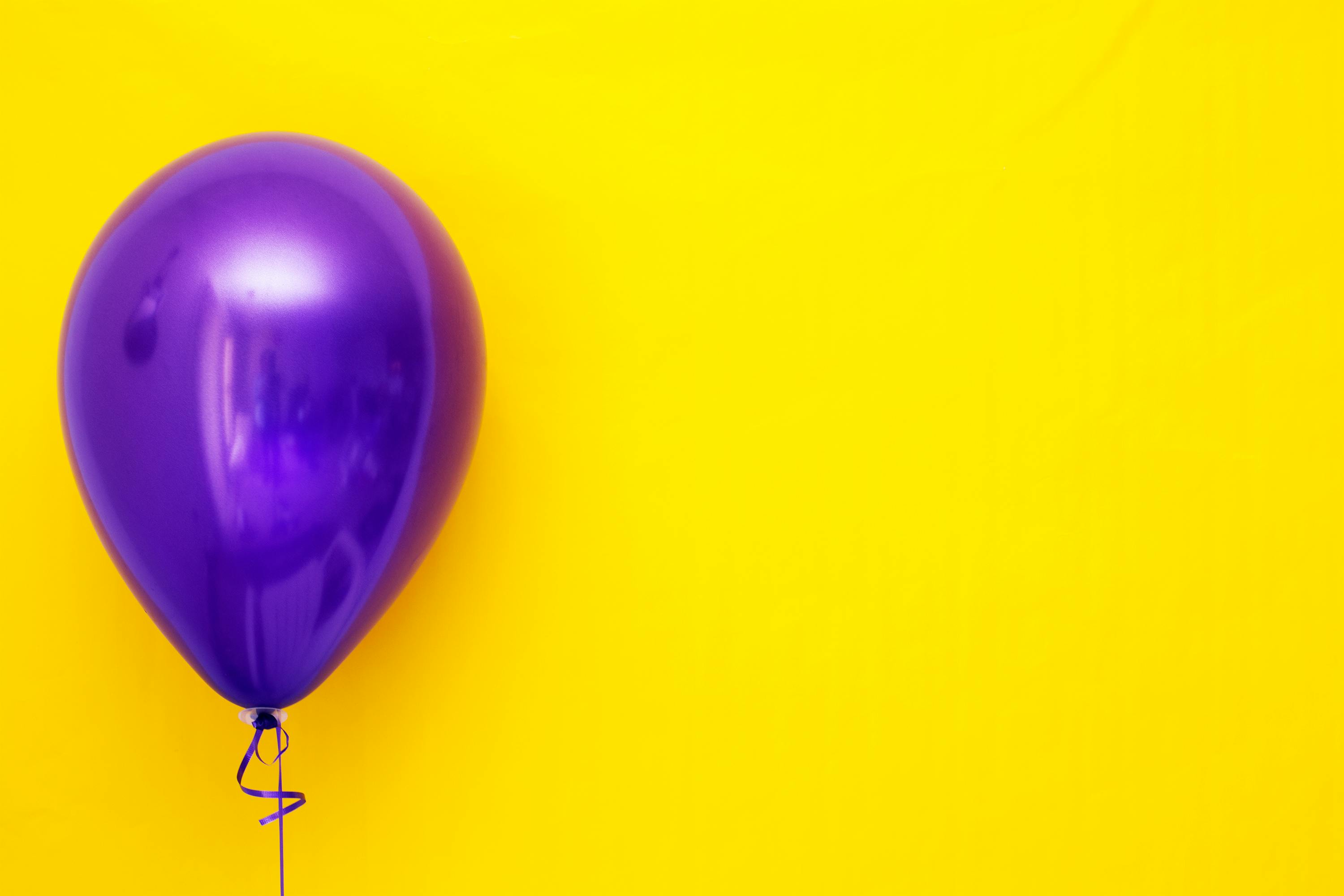 Palloncino Viola Su Sfondo Giallo · Immagine gratuita