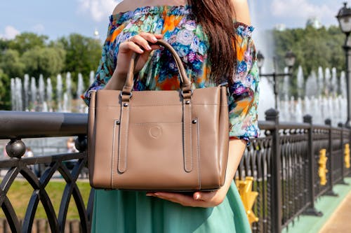 Photo of Person Holding Brown Leather Handbag