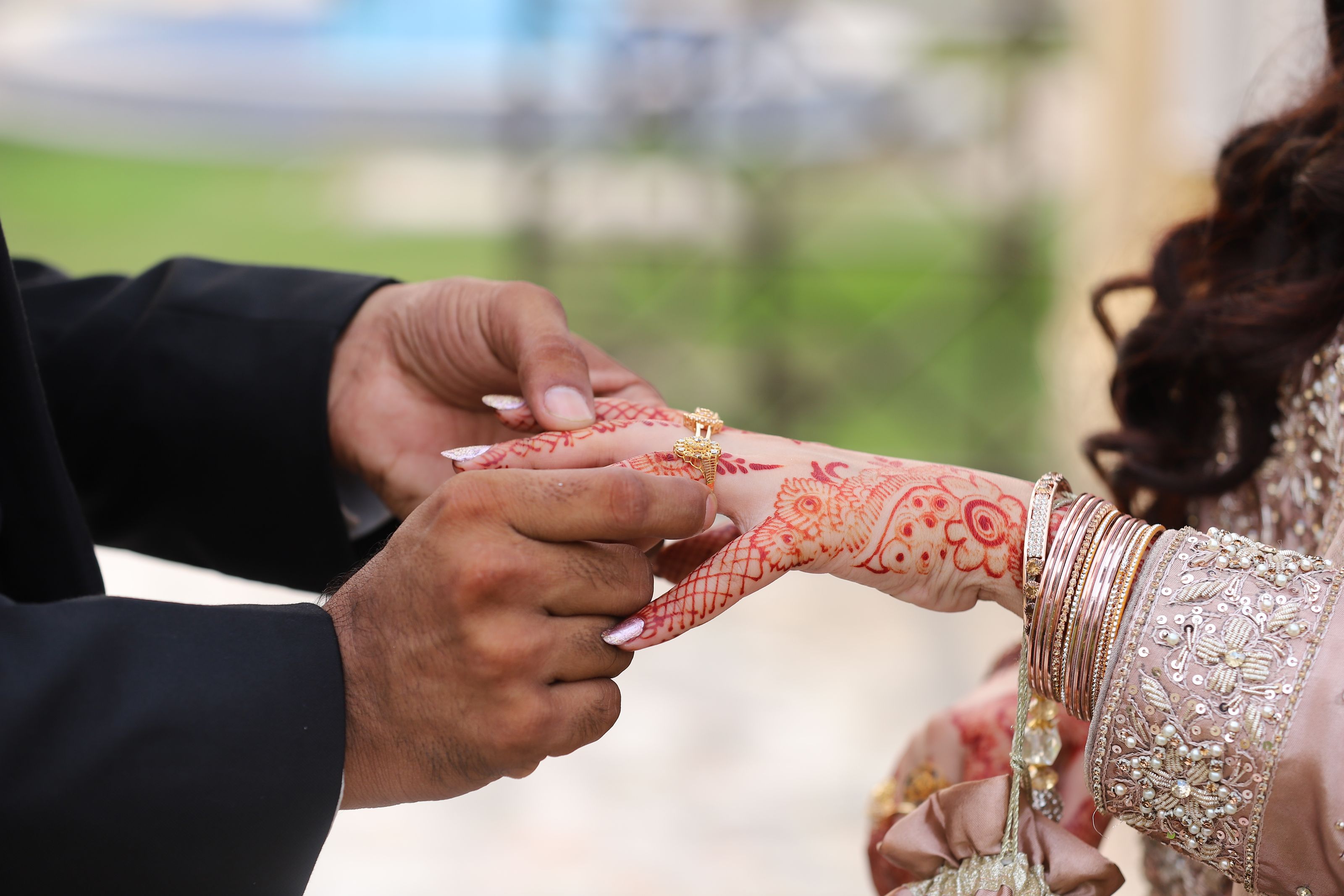 Ring exchange close-up — groom placing ring