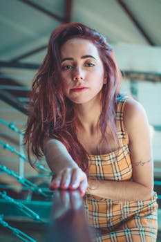 室内，一个红发女人穿着格子连衣裙，靠在栏杆上