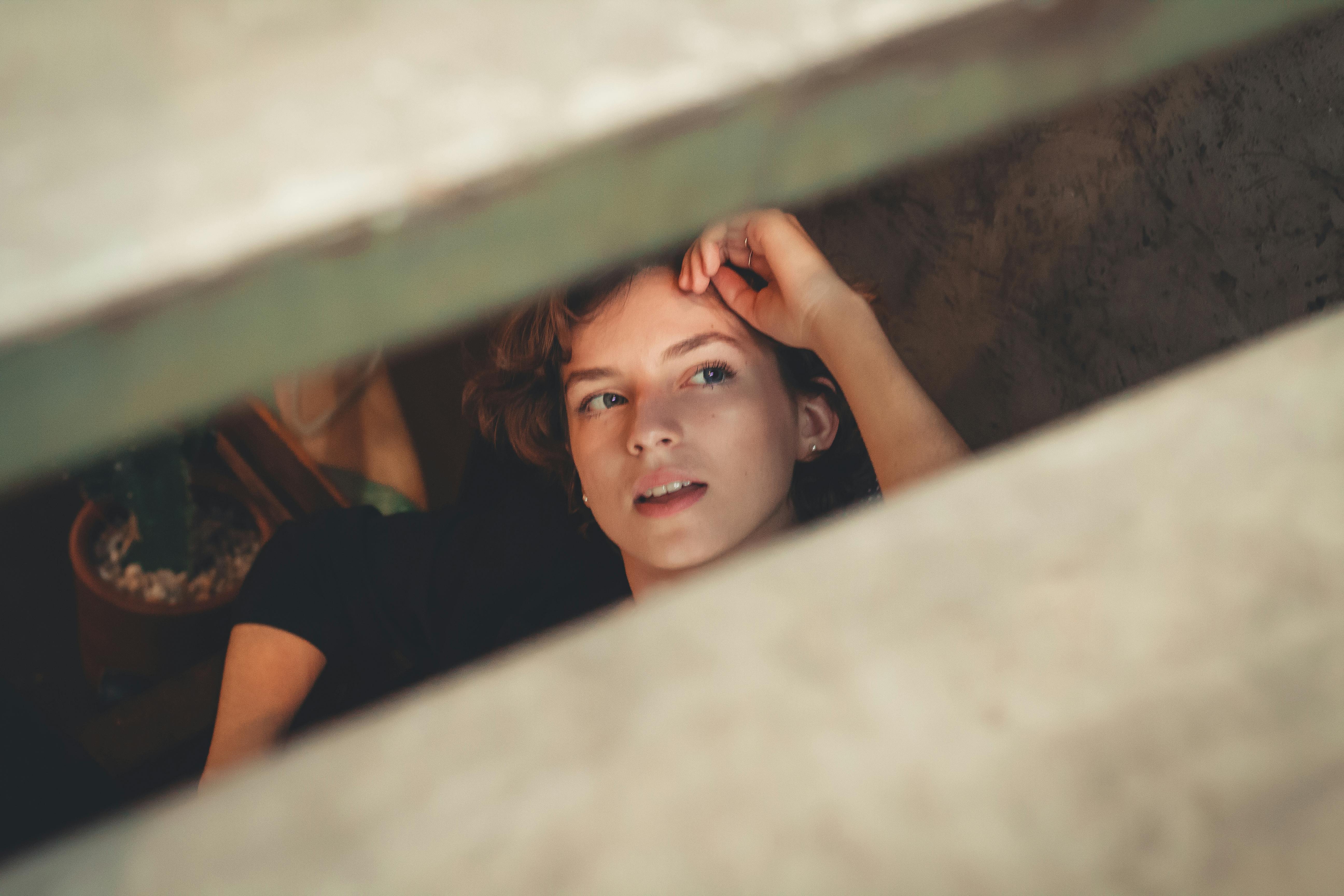 一位年轻女子若有所思地凝视着木板条，勾勒出一幅内省而富有选择性的肖像