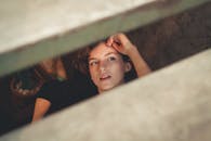 一位年轻女子若有所思地凝视着木板条，勾勒出一幅内省而富有选择性的肖像