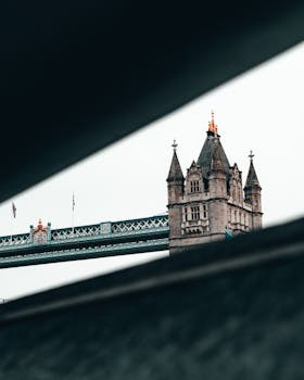 Artistic shot of Tower Bridge's gothic towers against a moody sky, London, UK.