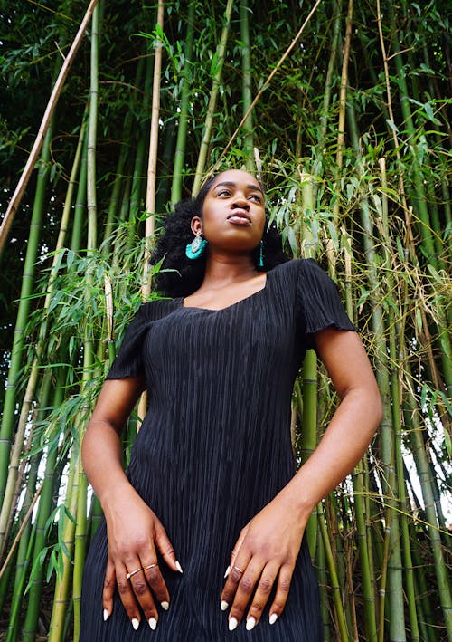 女人站在竹樹旁邊的低角度照片