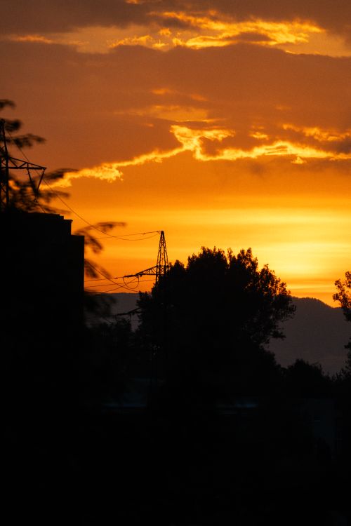 Free Dramatic urban silhouette with vibrant golden sky during sunset. Stock Photo