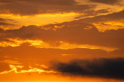 Free A mesmerizing sunset with vibrant golden clouds creating a dramatic sky scene. Stock Photo