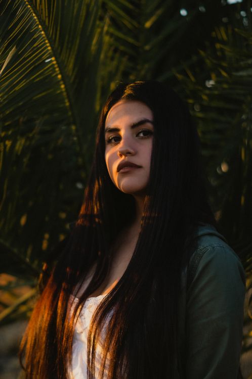 Photo of a Woman Standing Near Green Palm Tree · Free Stock Photo