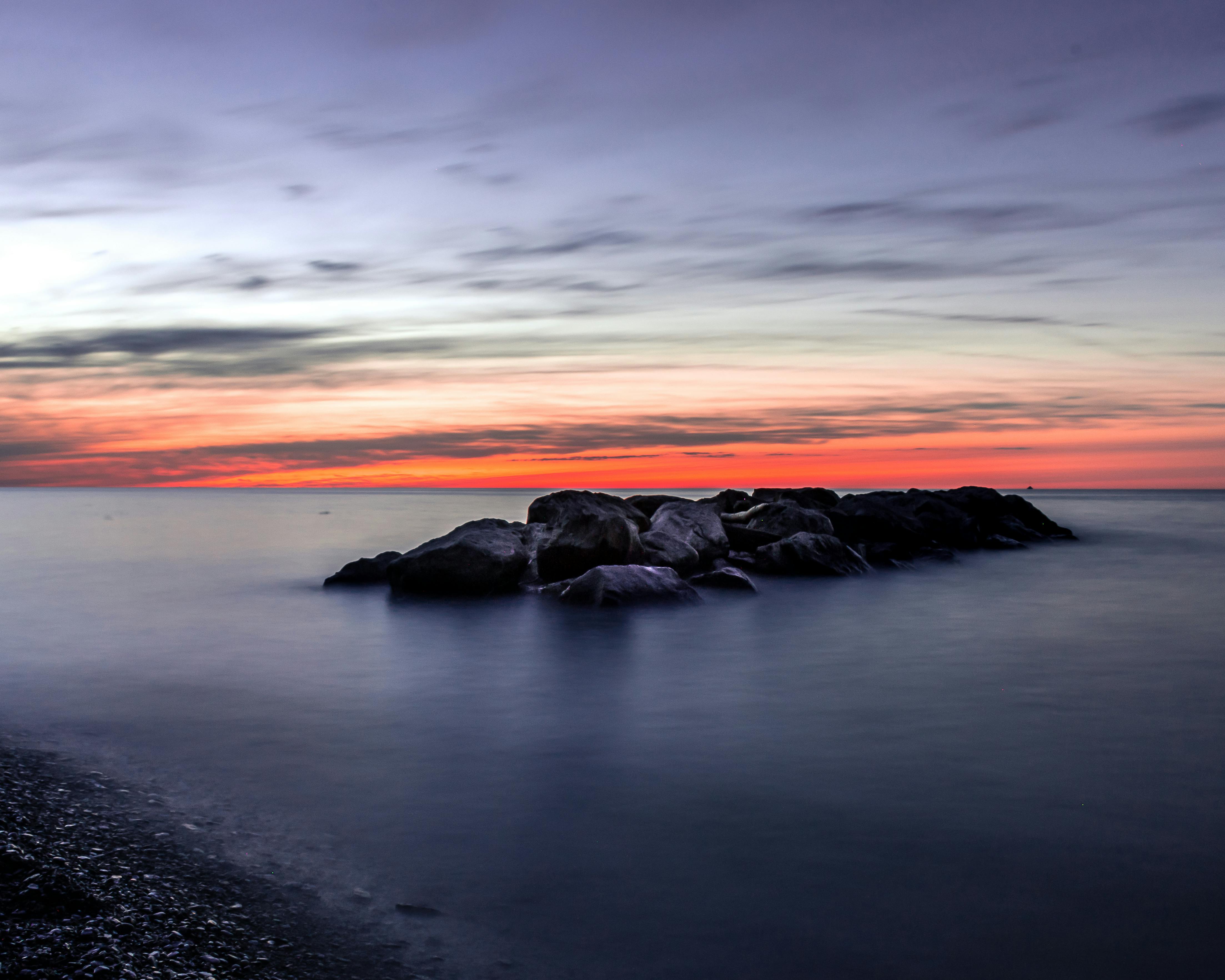 日落时分，迷人的海景以宁静的水域和多岩石的海岸线为特色