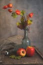An apple and flowers in a vase on a table
