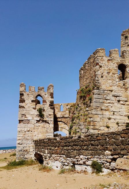 Explore stunning medieval castle ruins by the seaside with a clear blue sky.