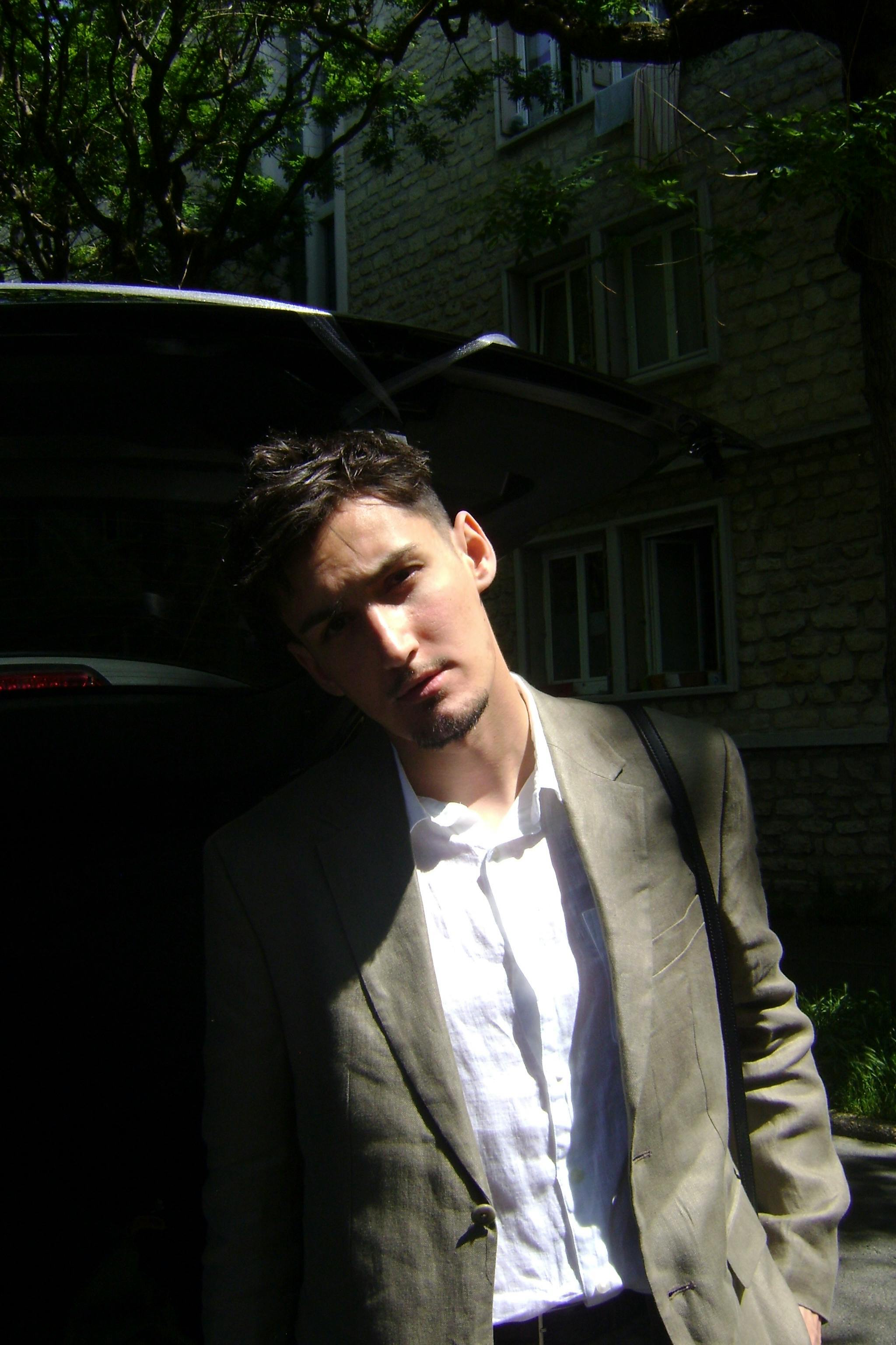 Portrait of a man in a suit standing outdoors, showing urban fashion style.