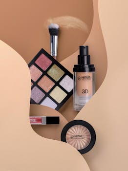 Flat lay of cosmetics including eyeshadow, lipstick, and blush with neutral tones.