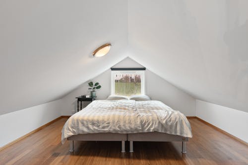 A white bed in an attic bedroom