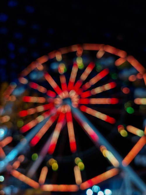 A blurry photo of a ferris wheel at night