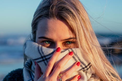 Foto Del Primo Piano Di Una Donna Che Copre Il Viso Con La Sciarpa