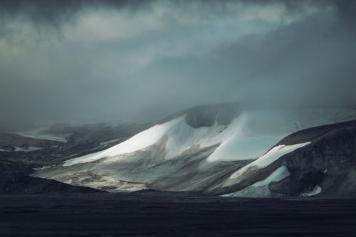 Free Snow-covered mountain under dramatic skies, showcasing a cold, wintery scene. Stock Photo