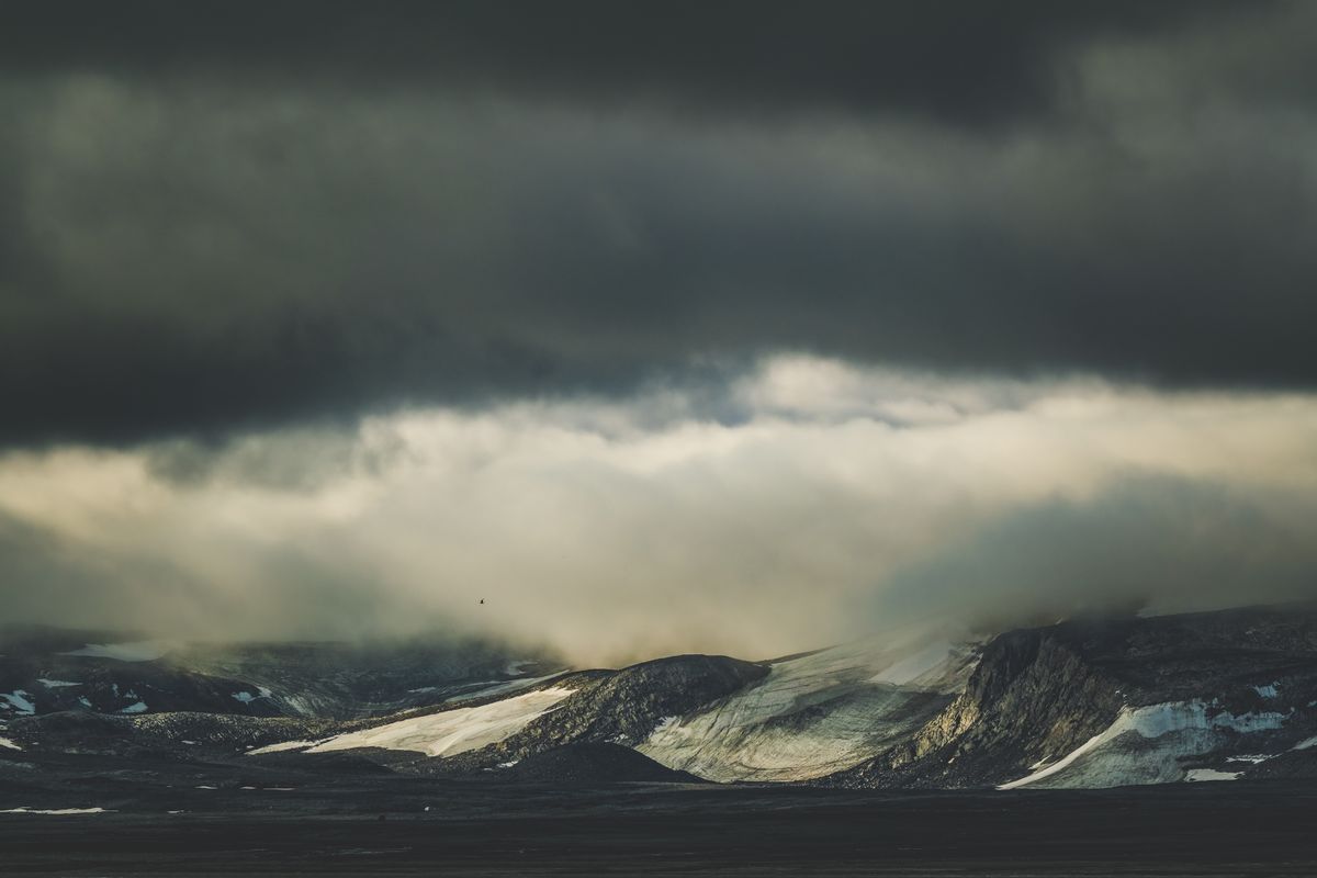 Moody mountain range beneath a heavy overcast sky — photo by Francesco Ungaro on Pexels