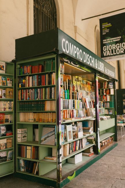 A vibrant Italian bookstore displaying diverse books and records in a classic urban setting.