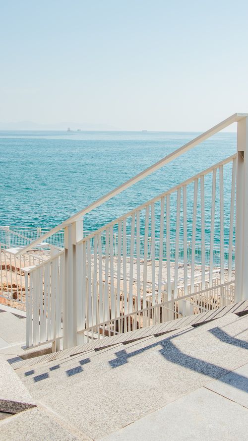 Free Serene coastal promenade showing clear blue sea and sky, perfect for relaxation and travel inspiration. Stock Photo
