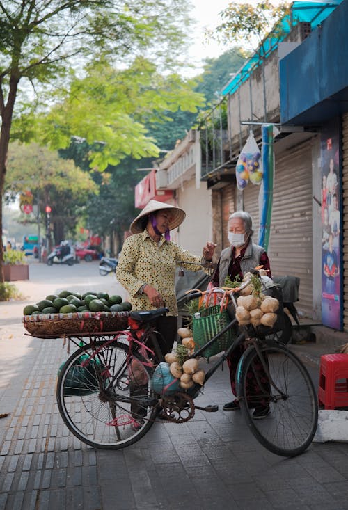 A woman on a bicycle with a basket of vegetables