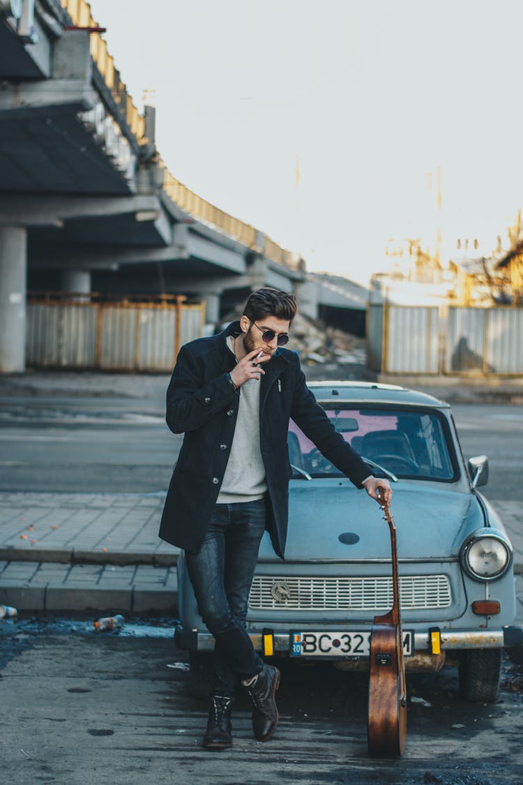 Photo Of Man Smoking While Standing In Front Of Old Car