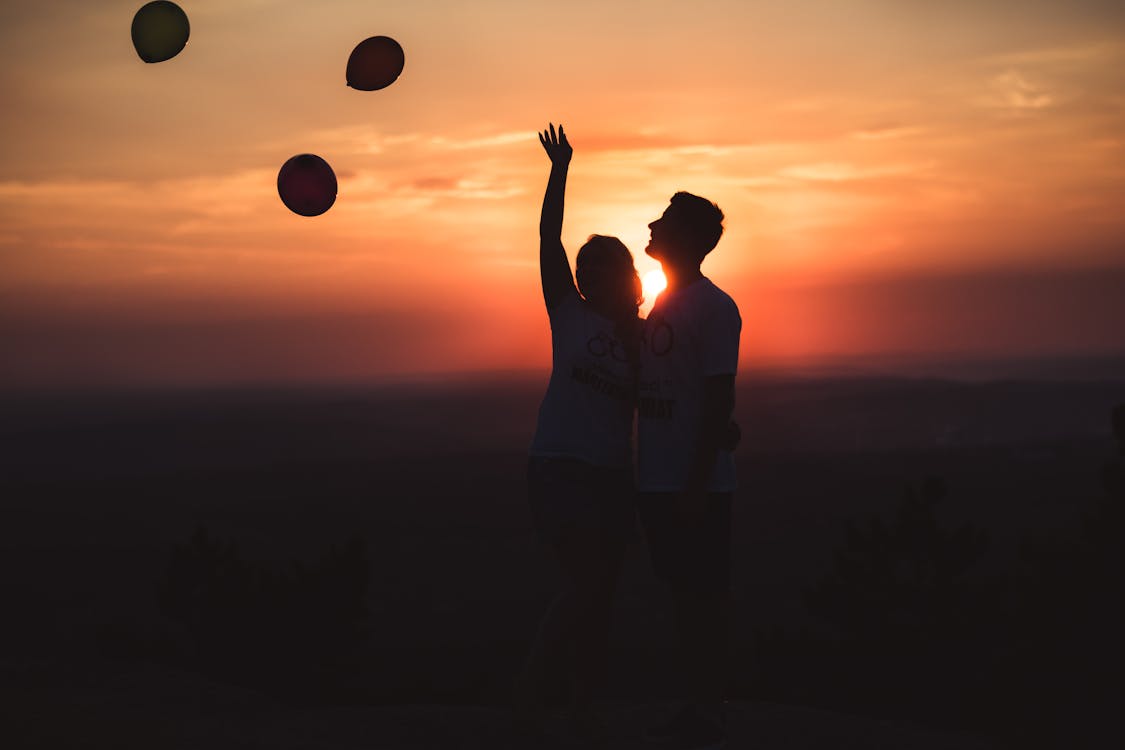 Free Silhouette Photo of Couple Standing Outdoors Stock Photo
