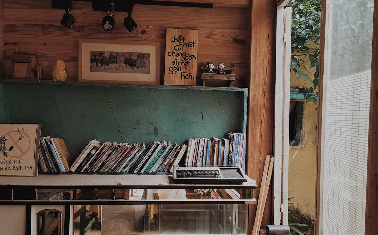 Books in Teal Wooden Rack on Wall