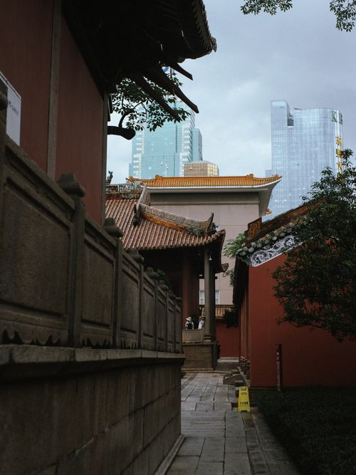 Free Ancient Buddhist temple contrasts with modern skyscrapers, showcasing urban diversity. Stock Photo