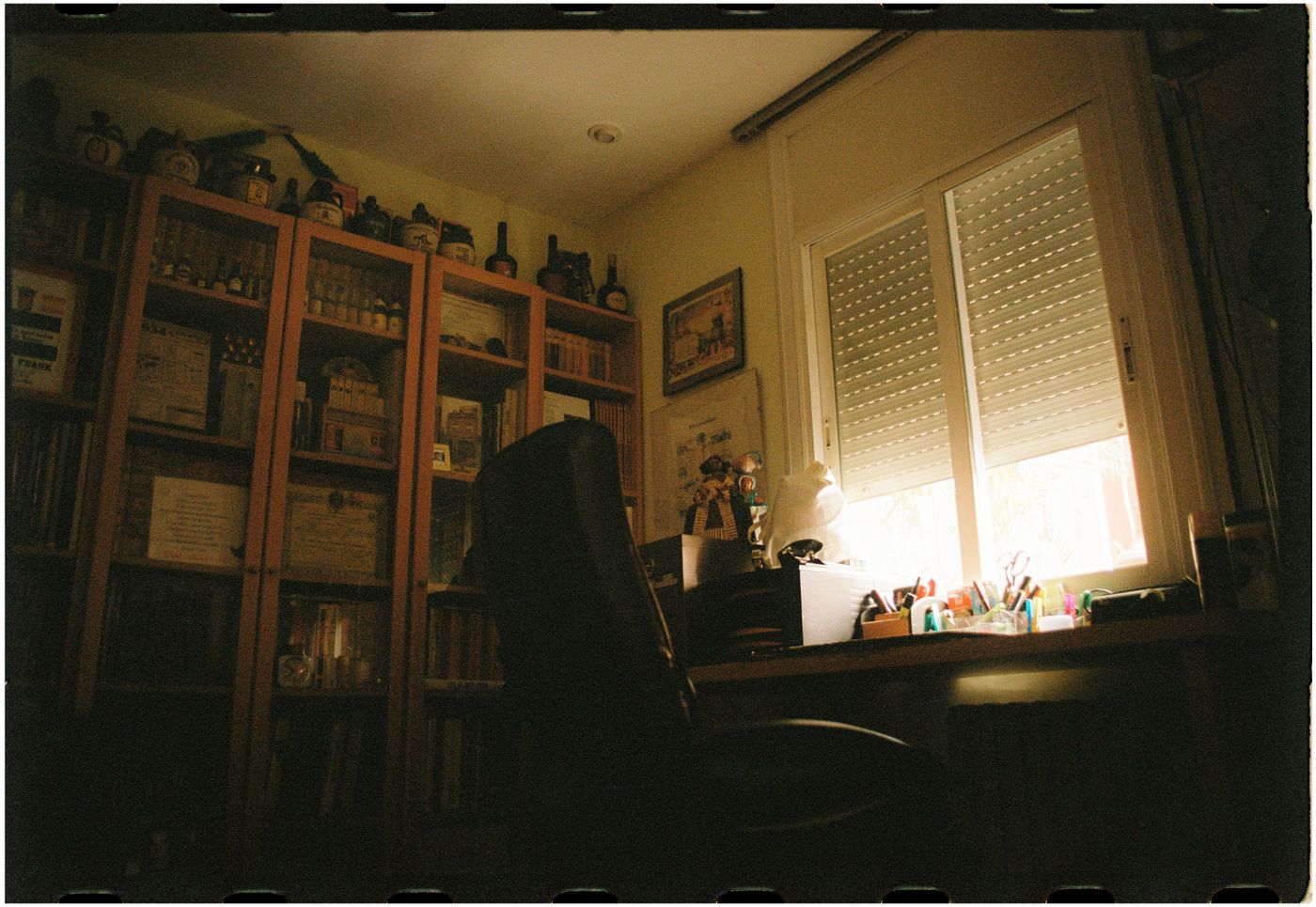 Cozy home office with bookshelf desk and warm lighting