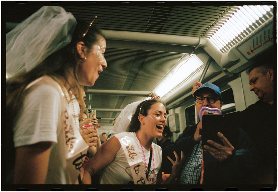 Celebratory bachelorette party with friends on a subway showcasing fun and laughter.