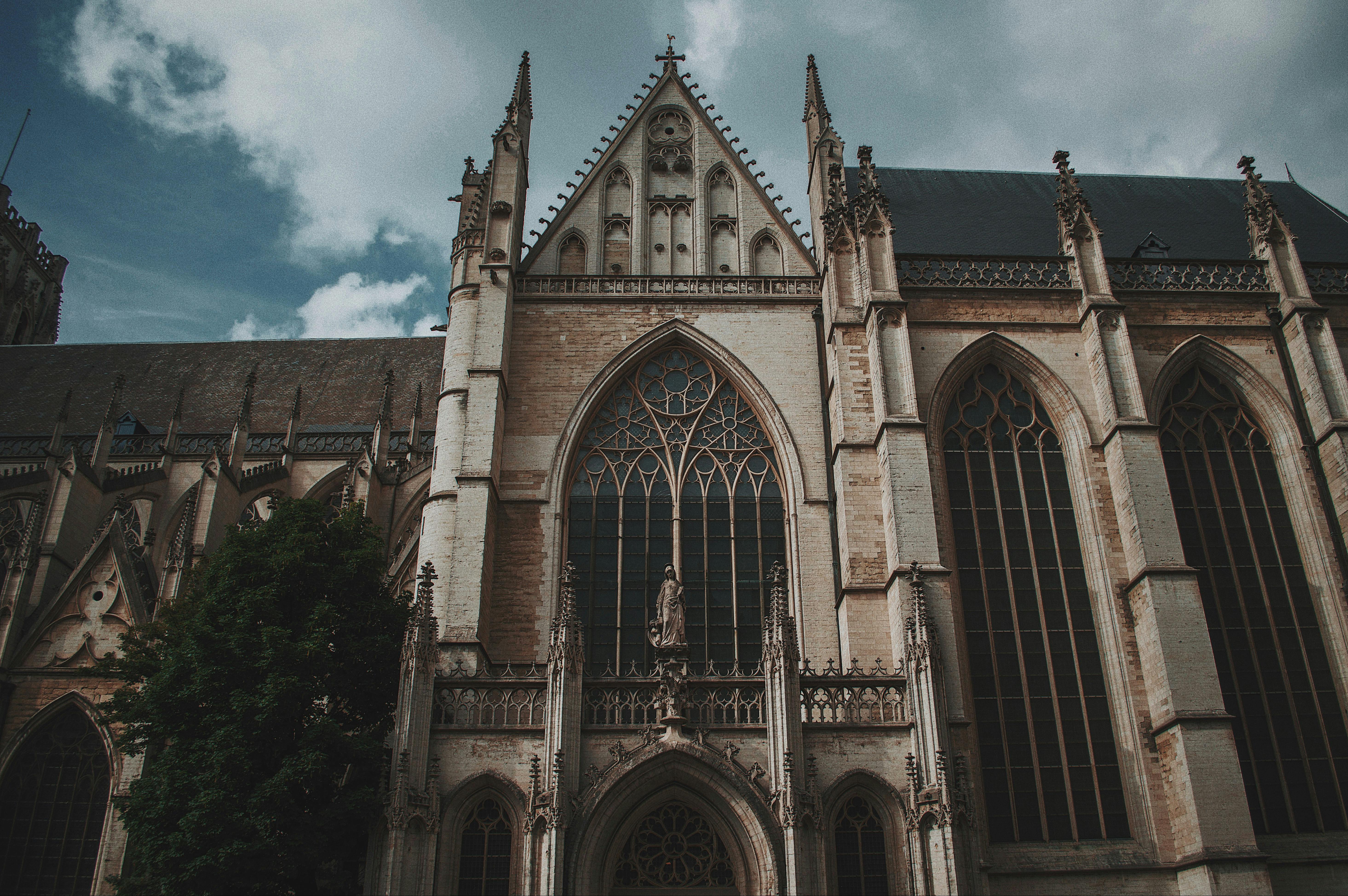 从低角度拍摄的雄伟哥特式大教堂立面，在多云的天空下展现出复杂的建筑细节